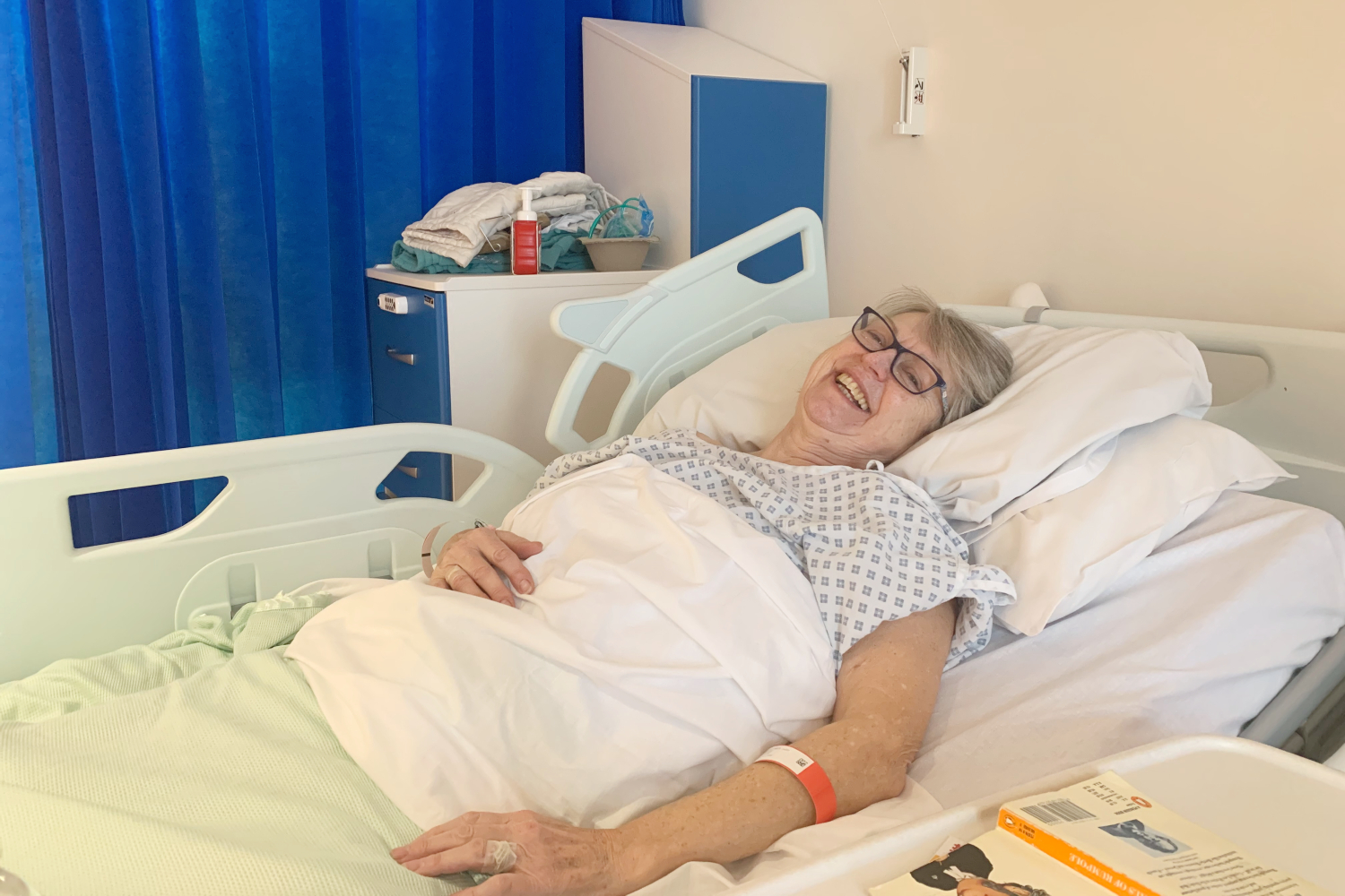 A patient smiling in their hospital bed.