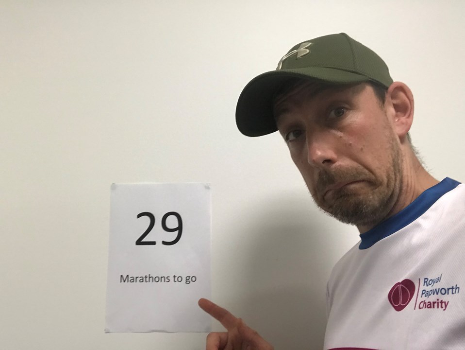 Andy wearing a Royal Papworth Charity t-shirt with a sign saying '29 marathons to go'
