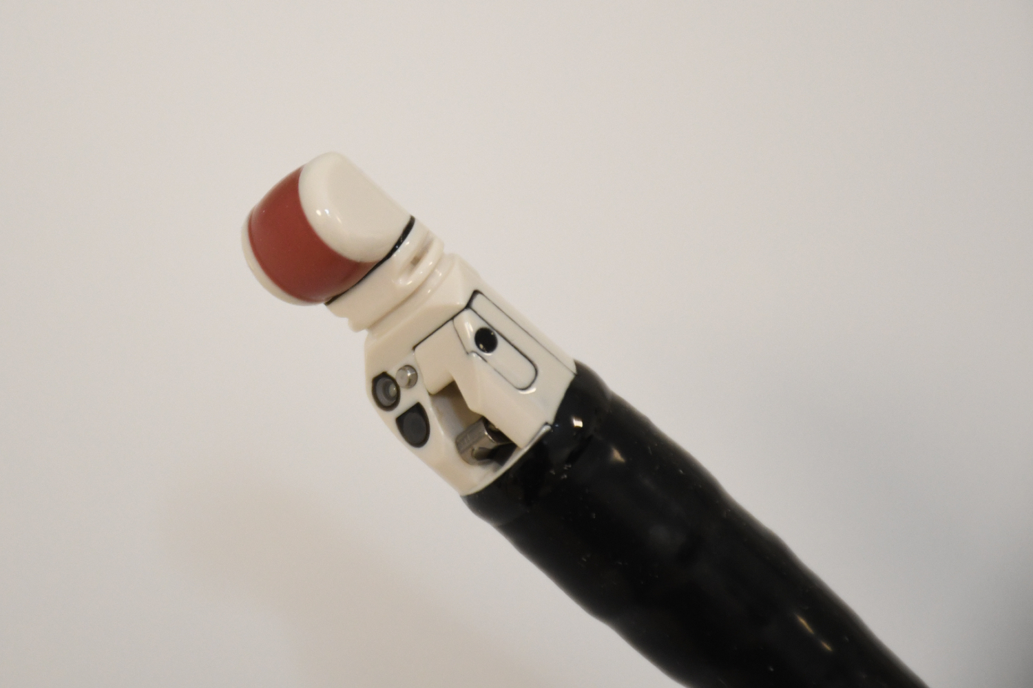 A black pole with a white end and red strip.