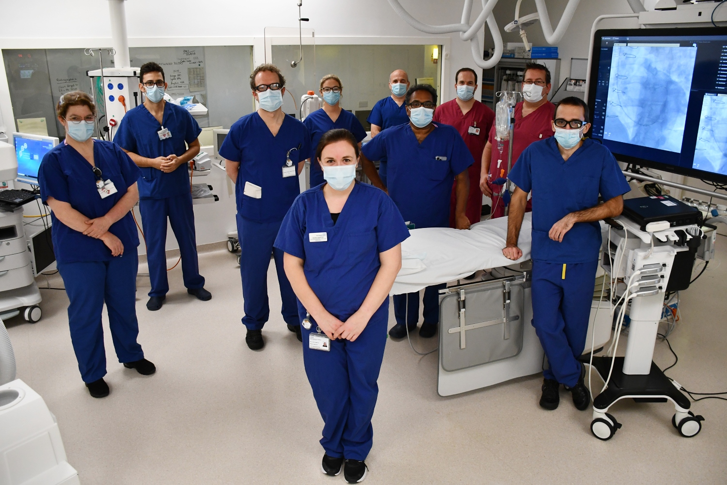 A group of people wearing blue and red scrubs, standing. 