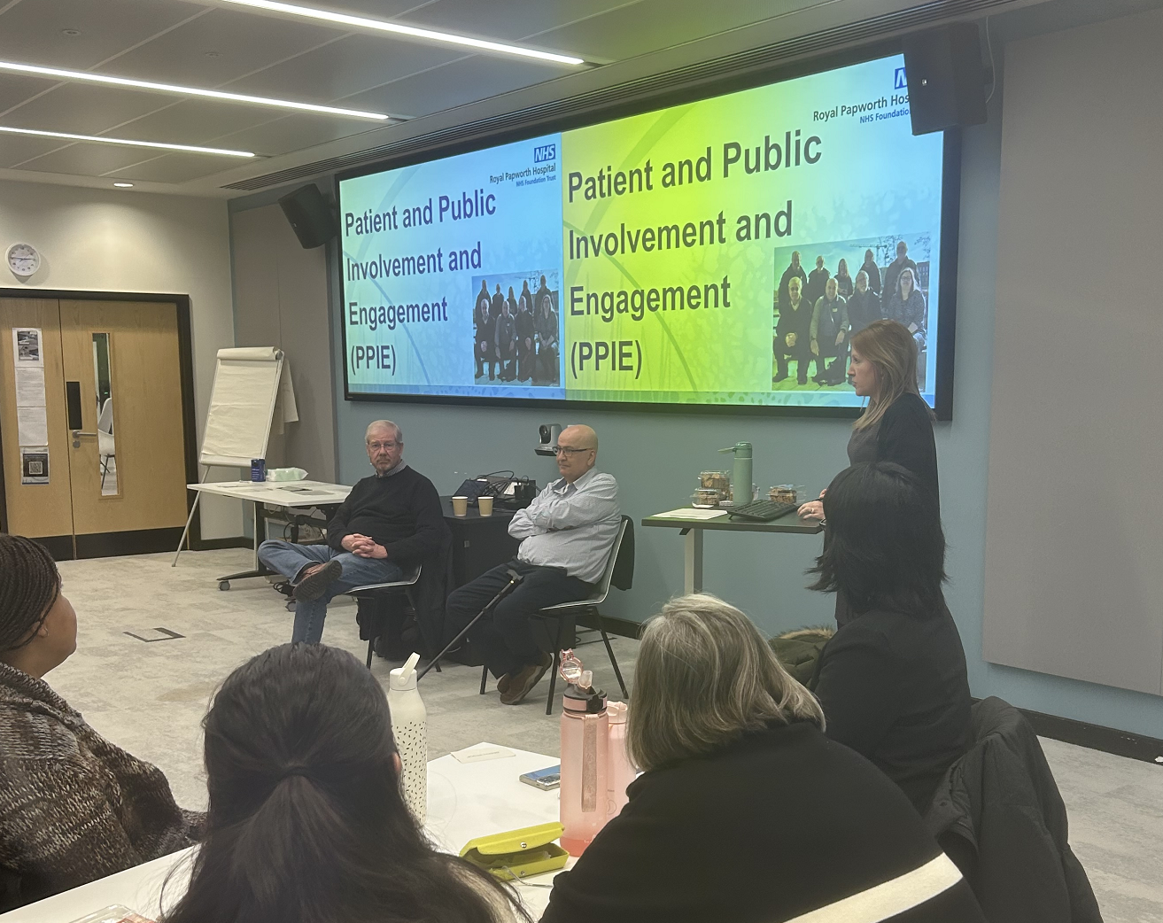 Research Skills Course participants in a room attentively watching the Patient and Public Involvement and Engagement session, presented by the Clinical Project Manager and two Research Ambassadors.