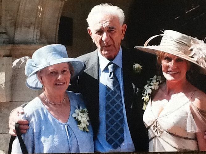 Diane, now as an adult, with her parents at a wedding