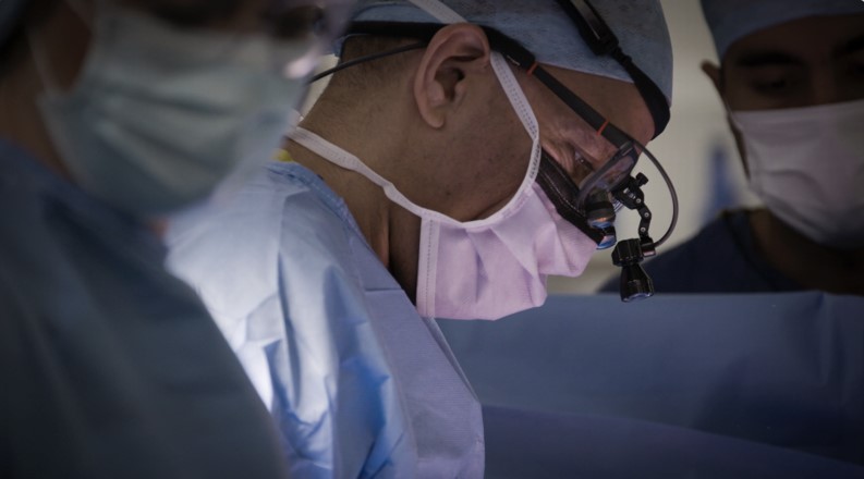 A person in a mask in an operating theatre.